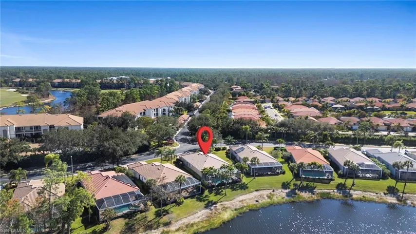 Aerial view of property's location featuring a nearby body of water and nearby suburban area