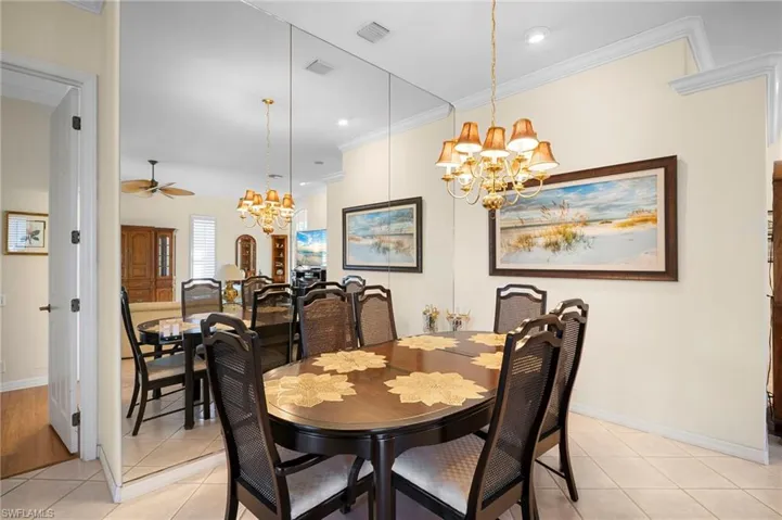 Dining area with hanging lights, crown molding, light tile patterned floors, and a ceiling fan