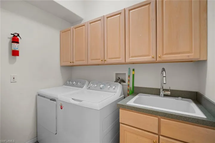 Laundry room featuring washer and clothes dryer and cabinet space