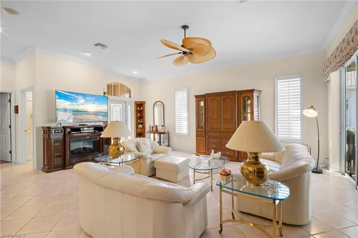Living room with crown molding, a ceiling fan, light tile patterned floors, plenty of natural light, and recessed lighting