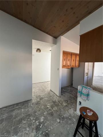 View from Dining Room to Kitchen and Entrance. Beautiful wood ceilings through out.
