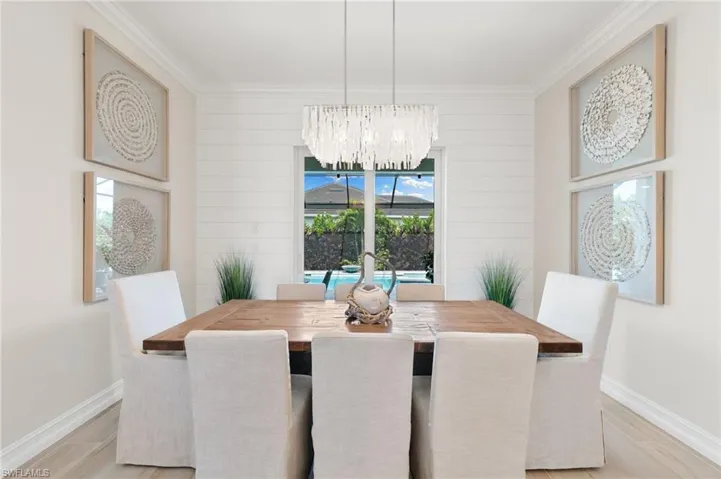 Dining room with a chandelier, light wood-type flooring, and ornamental molding