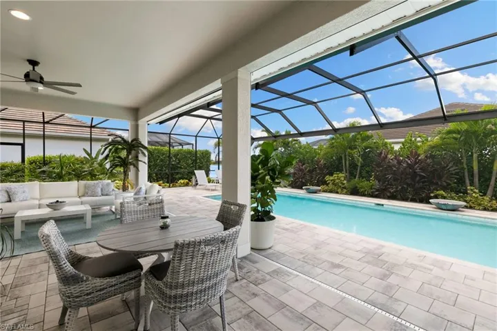 Outdoor pool featuring a sunroom, glass enclosure, a ceiling fan, outdoor lounge area, and a patio area