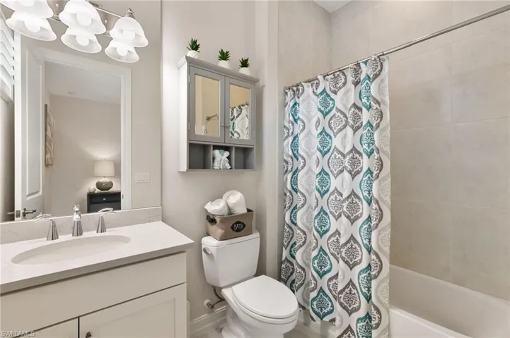 Full bath with vanity, shower / tub combo, and a chandelier