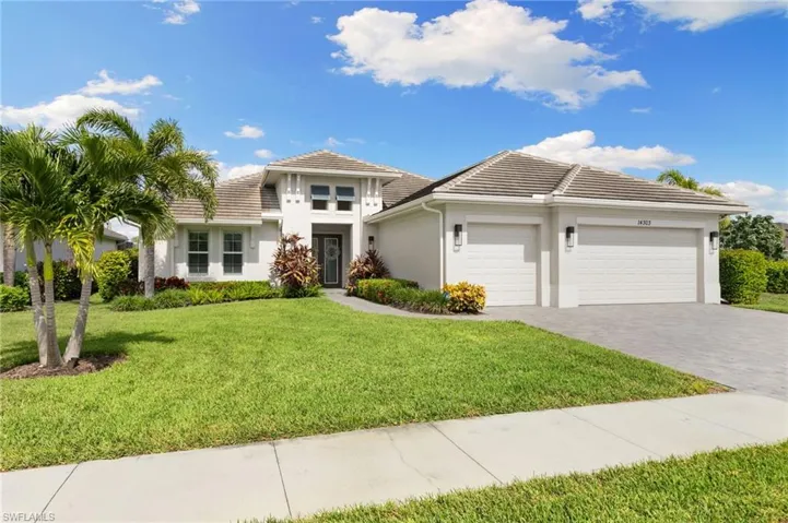 Prairie-style house with an attached garage, stucco siding, decorative driveway, a tile roof, and a front yard
