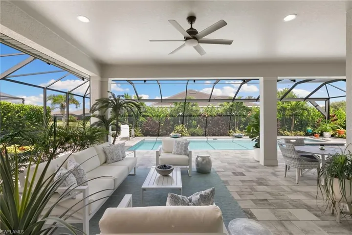 View of patio / terrace with a sunroom, a ceiling fan, a lanai, an outdoor pool, and outdoor lounge area