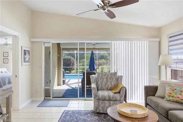 Bright living area with large sliding doors that open directly to the screened lanai and pool.