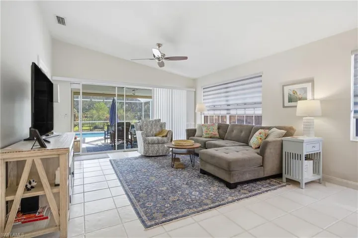 Spacious living room with vaulted ceilings and tile flooring creating an open and airy feel.