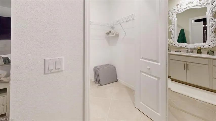 Spacious closet featuring light tile patterned floors and a sink