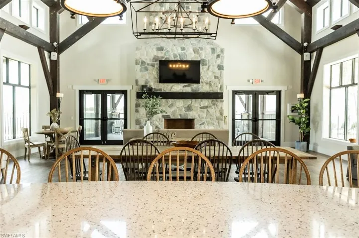 Dining space featuring french doors, a towering ceiling, plenty of natural light, a chandelier, and wood finished floors
