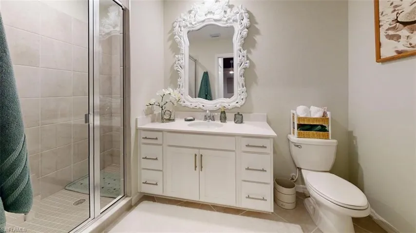 Full bath featuring a shower stall, vanity, and light tile patterned floors