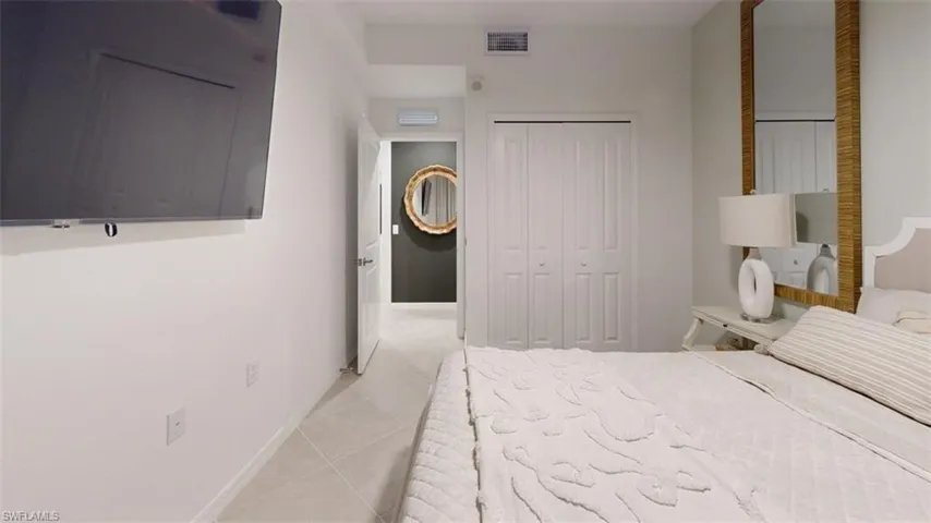 Bedroom featuring light tile patterned floors and a closet