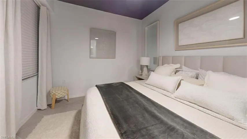 Bedroom featuring light tile patterned floors and baseboards