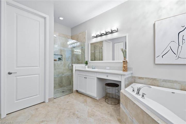 Master Bathroom with dual vanities, walk-in shower, soaking tub and water closet
