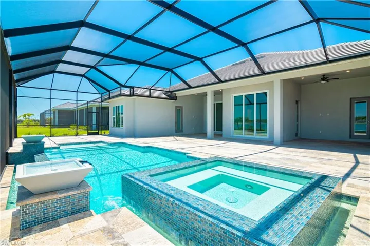 View of swimming pool with ceiling fan, a patio, glass enclosure, and an in ground hot tub