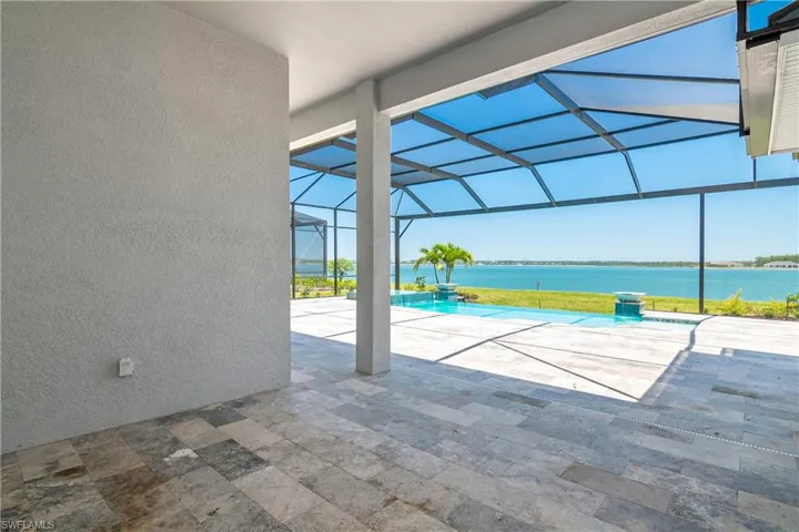 View of swimming pool featuring a patio, a water view, and a lanai