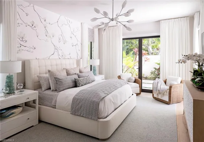 Bedroom featuring light carpet and an inviting chandelier