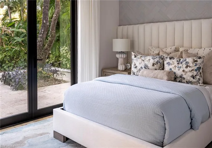 Bedroom featuring hardwood / wood-style floors, access to outside, and multiple windows