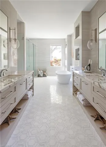 Bathroom with tile patterned flooring, vanity, separate shower and tub, and tile walls