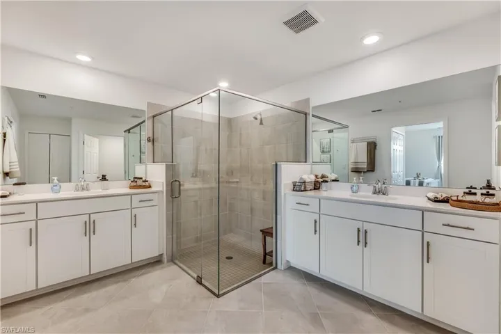 Bathroom with a shower with door, tile flooring, and vanity
