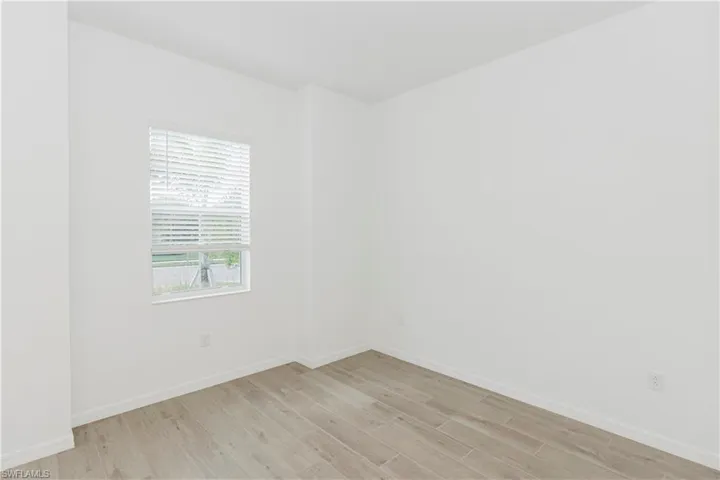 Unfurnished room with baseboards and light wood-style flooring