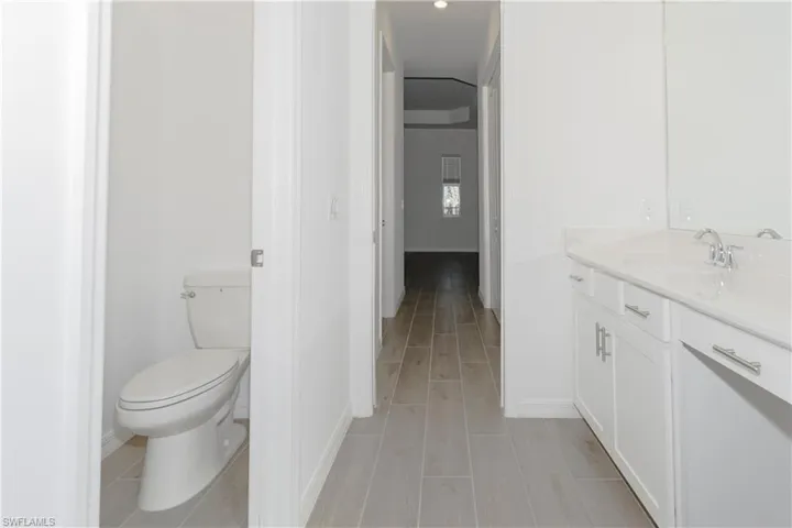 Bathroom featuring vanity, baseboards, and toilet