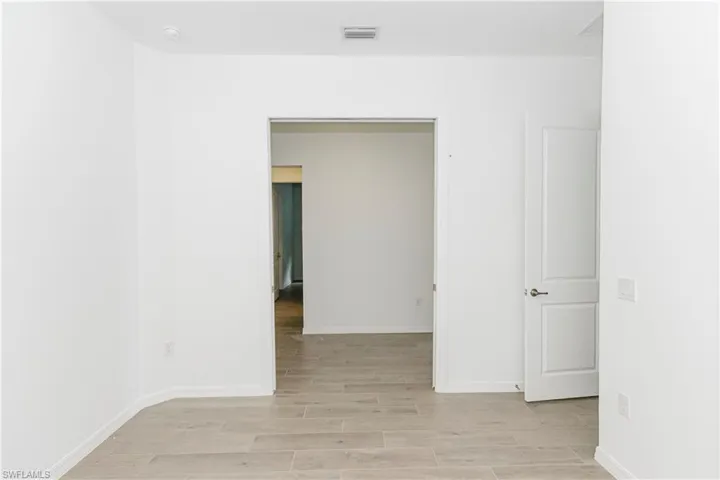 Empty room featuring baseboards, light wood-type flooring, and visible vents