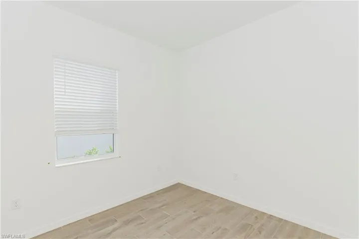 Unfurnished room featuring light wood-type flooring and baseboards