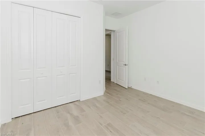 Unfurnished bedroom featuring a closet, baseboards, and light wood-type flooring