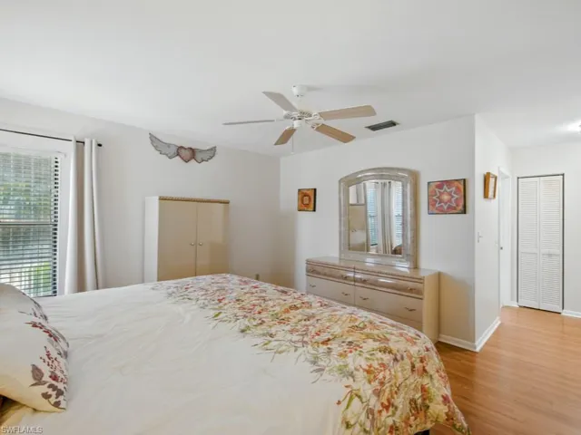 Primary bedroom with light wood-style flooring and a ceiling fan