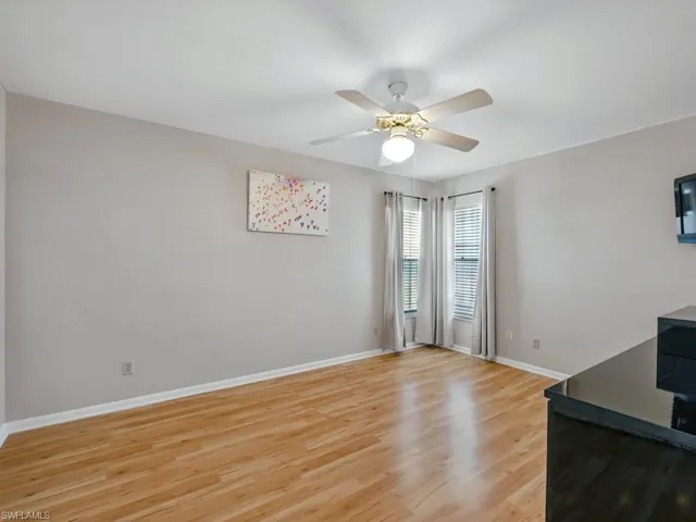Guest room with light wood-style flooring and a ceiling fan