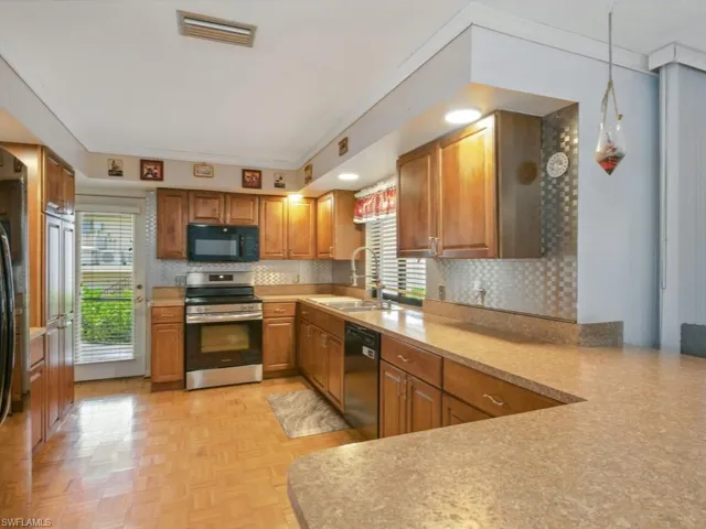 Extra large Kitchen with newer appliances, plenty of natural light, backsplash, and peninsula