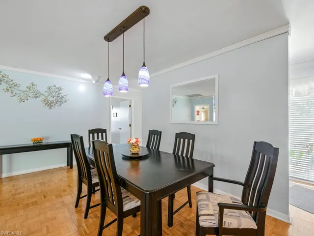Dining room with crown molding and baseboards pendant lighting