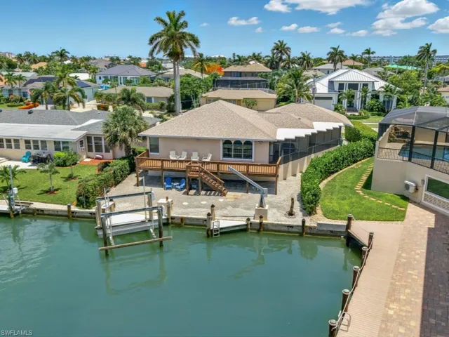 Dock area with a residential view, a deck with water view, stairway, and a lawn