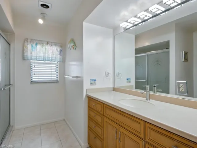 Primary bathroom with vanity, shower, and tile floors, high toilet