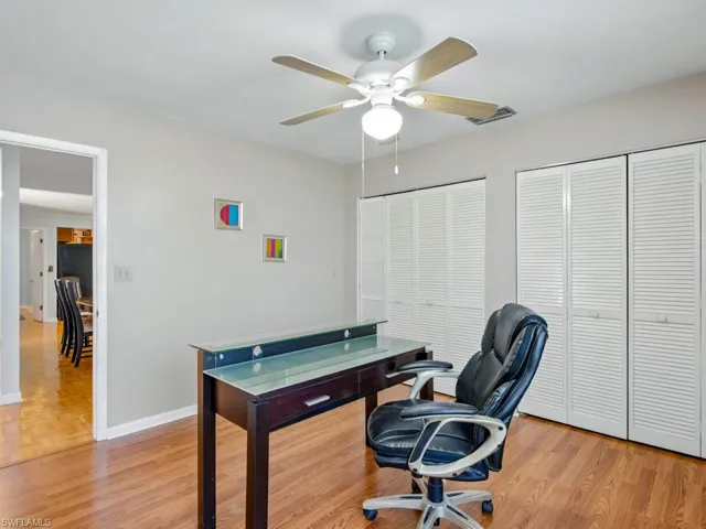 Home office featuring ceiling fan and light wood-type flooring and double closets