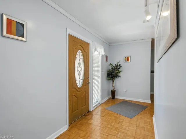 Foyer entrance with baseboards and ornamental molding