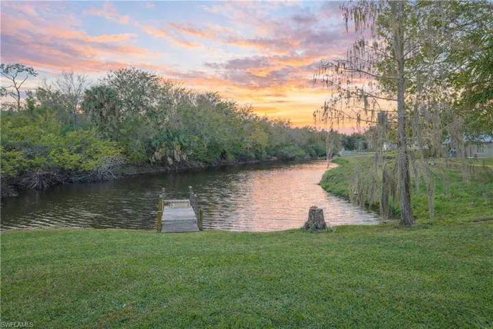 Dock area featuring a water view and a lawn