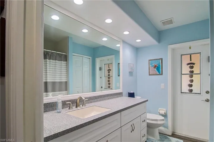 Bathroom featuring a shower with curtain, vanity, recessed lighting, and a closet