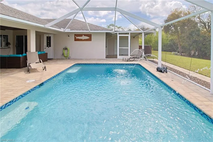 Swimming pool with a patio area, an outdoor living space, a sunroom, and glass enclosure