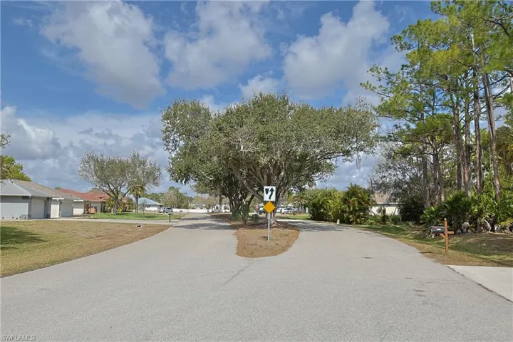 View of asphalt street featuring traffic signs and a residential view