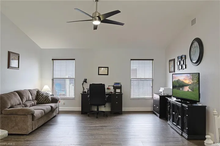 Office featuring vaulted ceiling, plenty of natural light, a ceiling fan, and dark wood-style flooring
