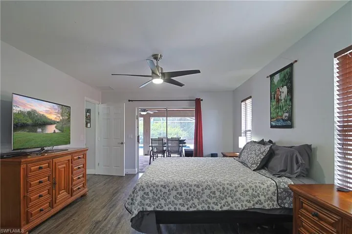 Bedroom featuring access to outside, dark wood-style floors, and a ceiling fan
