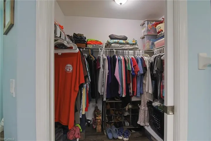 Walk in closet featuring dark wood finished floors