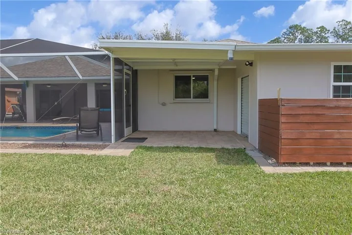 Rear view of house featuring a lanai, a patio, and stucco siding