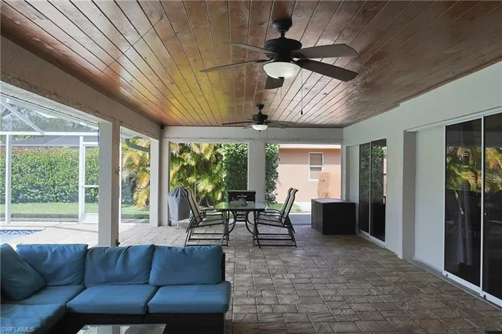 Sunroom featuring ceiling fan, outdoor dining space, a patio, and healthy amount of natural light