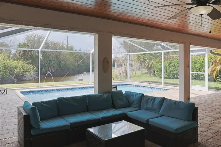 View of patio / terrace with an outdoor pool, a sunroom, a lanai, and ceiling fan