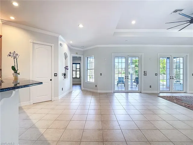 Entryway with french doors, ornamental molding, recessed lighting, light tile patterned floors, and arched walkways