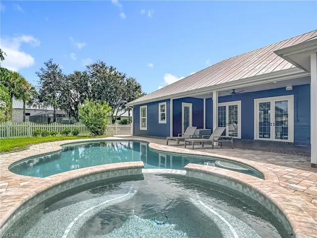 View of pool with french doors, a ceiling fan, a patio area, and a pool with connected hot tub