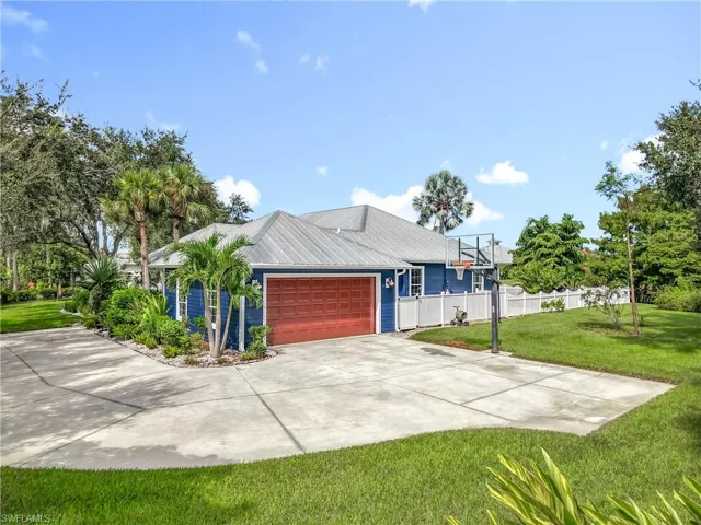 View of front of property featuring concrete driveway, an attached garage, and a metal roof